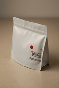Gatitu AA Kenya washed coffee bag — white matte packaging standing upright with red dot and tasting notes of blackberry, cacao, and caramel