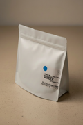 Dancer V3.0 Signature Blend coffee bag — white matte packaging standing upright with blue dot and tasting notes of floral, berry, and nougat
